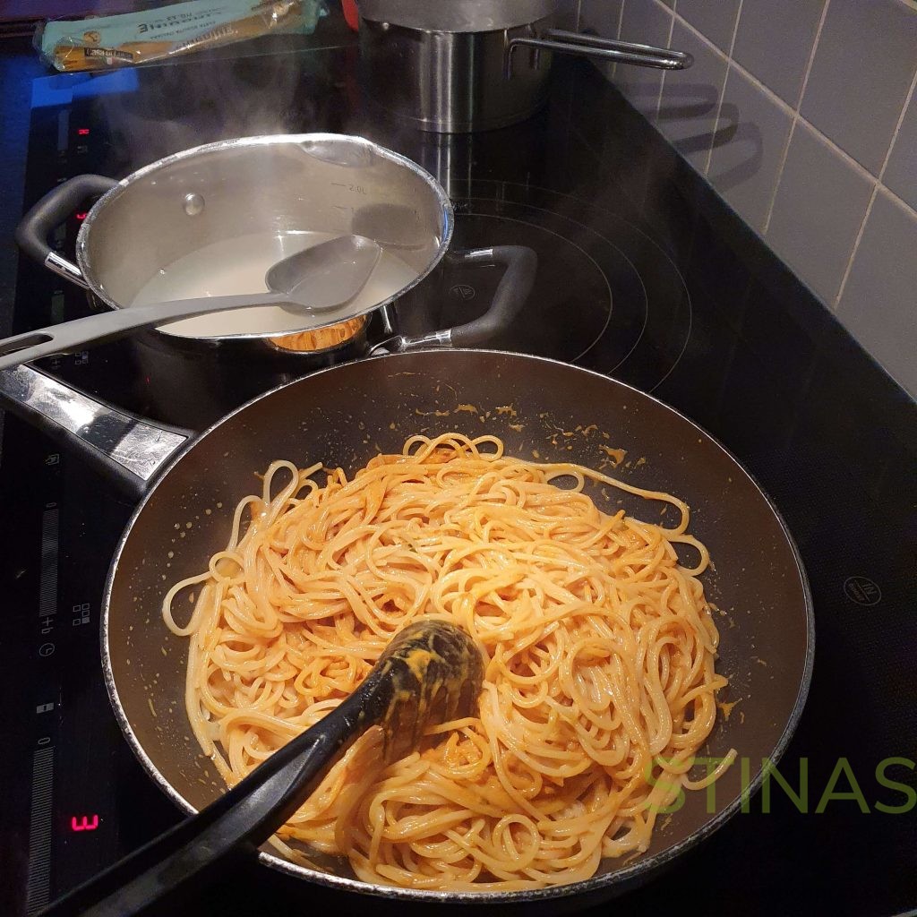 Pasta som håller på att matas med pastavatten för bästa krämighet